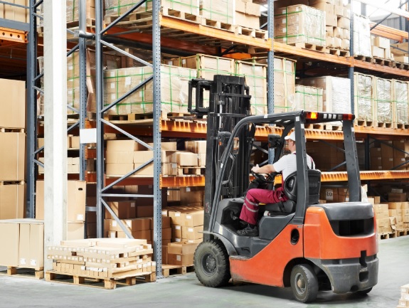 A worker operating a forklift in a warehouse, illustrating the need for training and expertise in seemingly simple tasks like job evaluations and compensation management.