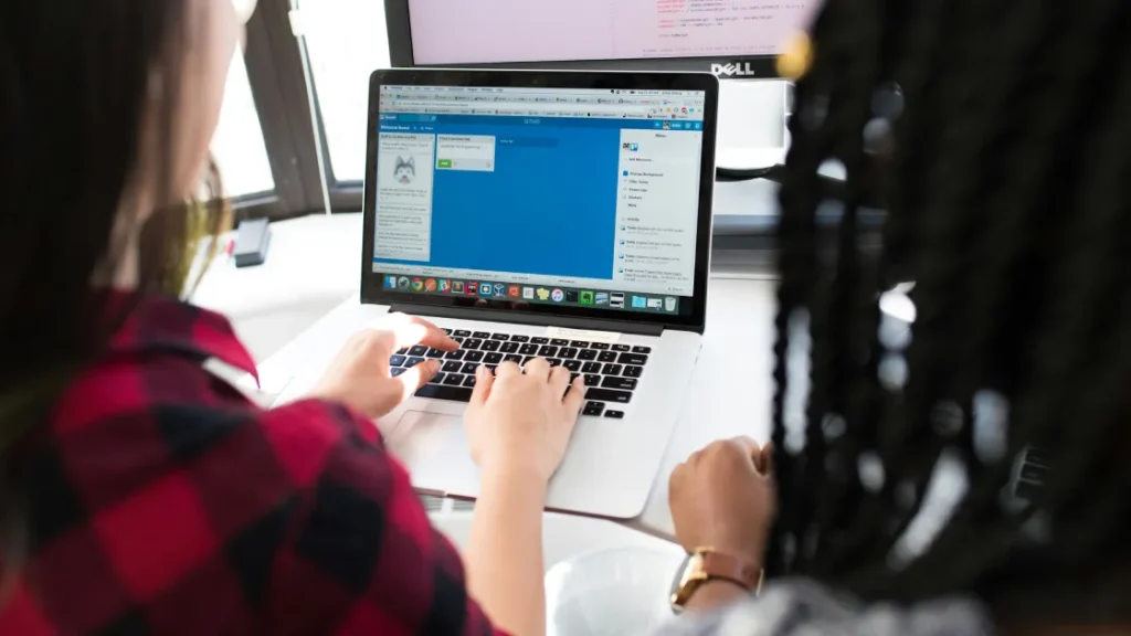 Employees using compensation management software on a laptop