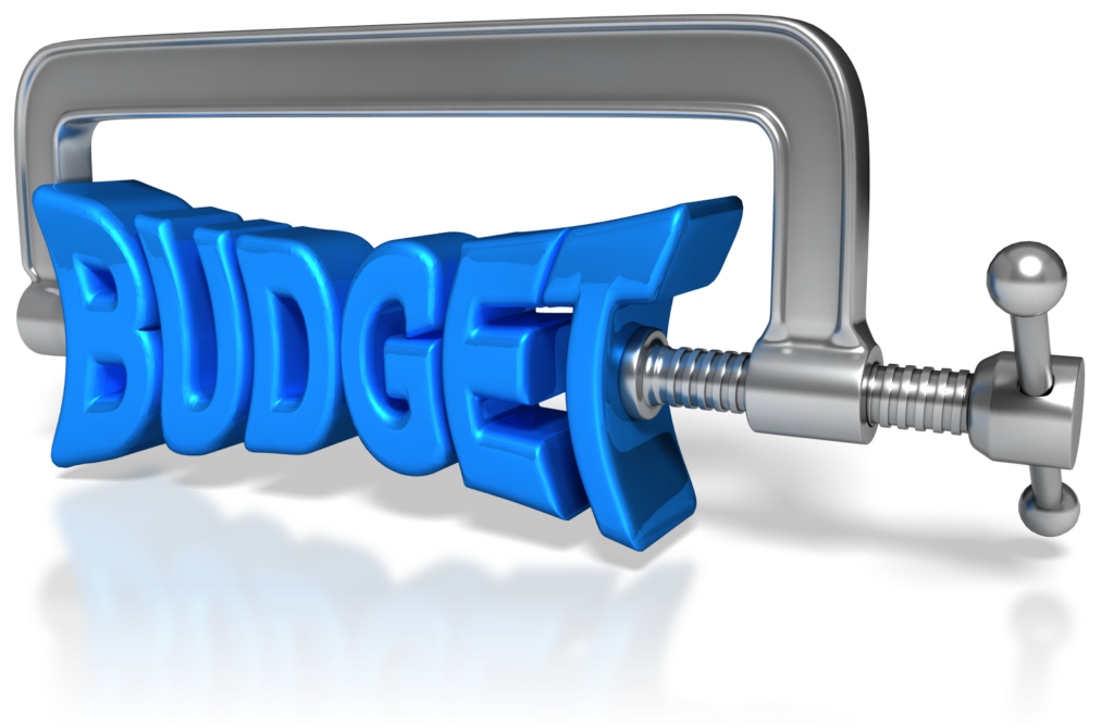 squeezing a dollar bill or a budget document, symbolizing the challenges of tight financial constraints during budget planning