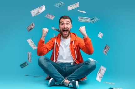 Excited man celebrating with cash falling around him, symbolizing financial rewards and employee bonuses.