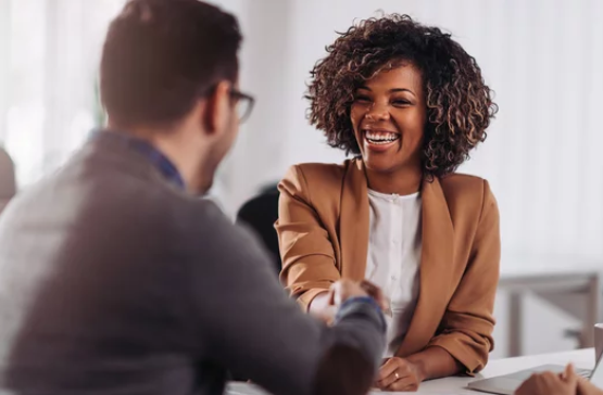 HR professional shaking hands with a candidate during a successful hiring process.